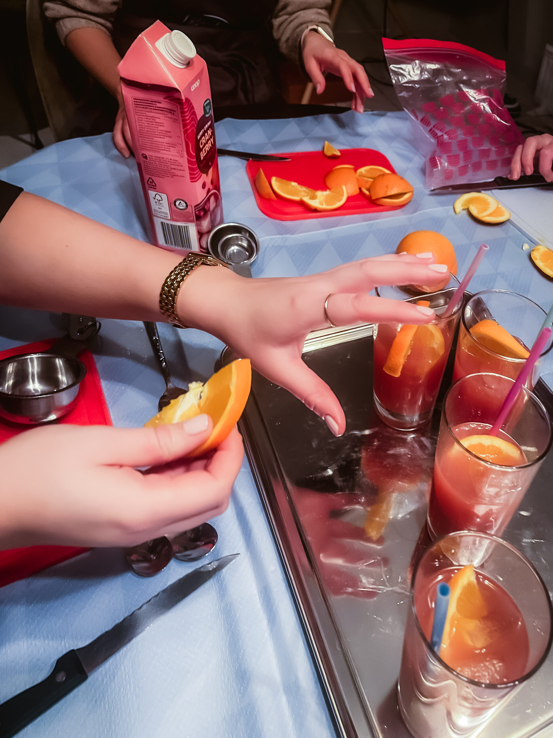 Bild från eventet Skapa något tillsammans: Två personer blandar alkohoholfria drinkar och dekorerar glasen med apelsinskivor.